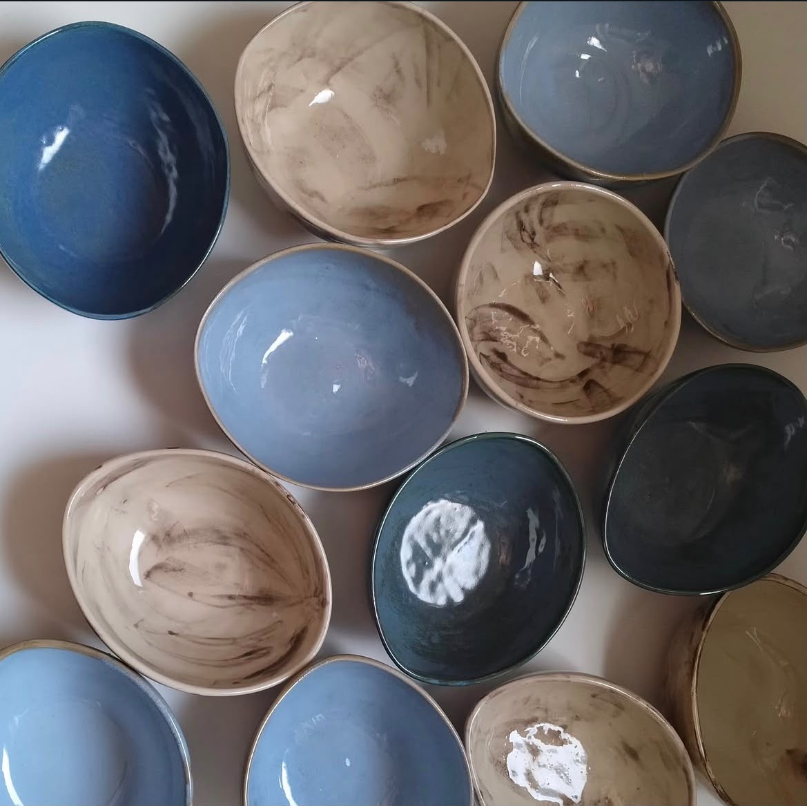 Overhead arrangement of handcrafted high-fired ceramic bowls in varied glazes