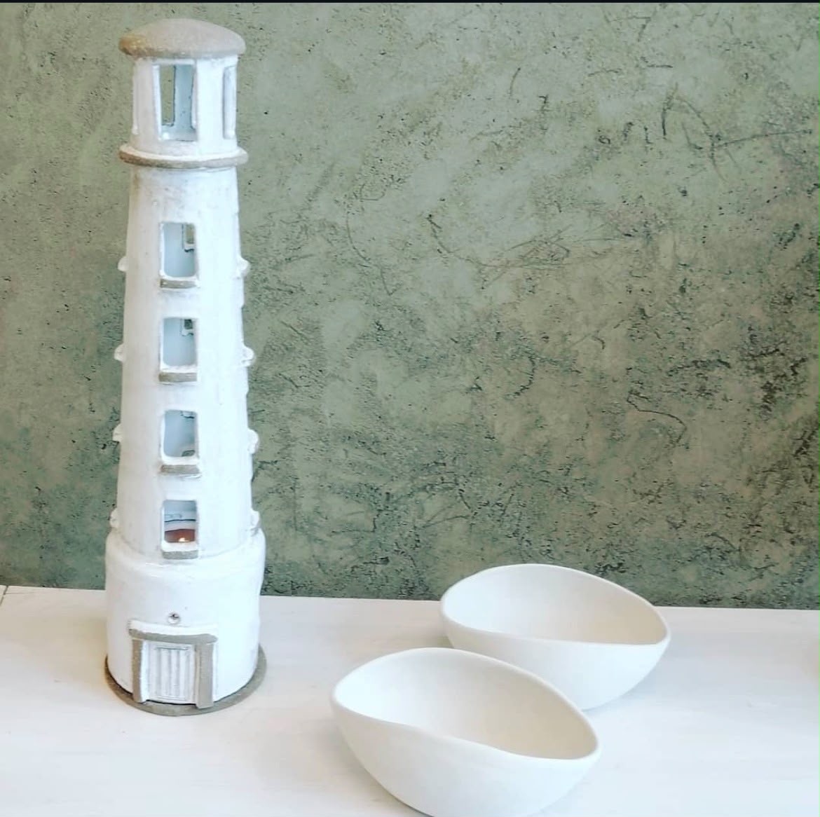 Ceramic lighthouse sculpture with pierced windows designed to hold light