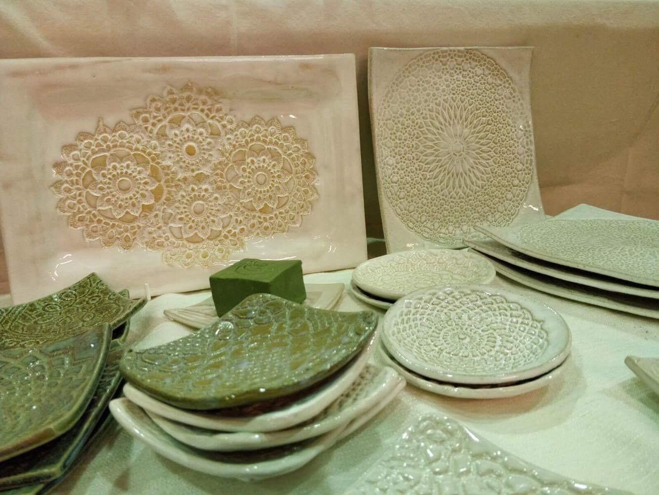 Group of cream and white ceramic relief plaques and dishes with repeated patterns